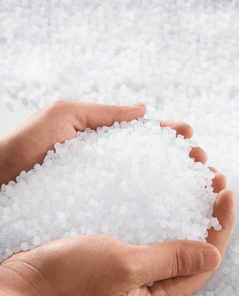 Two hands are holding many small plastic particles. (photo)