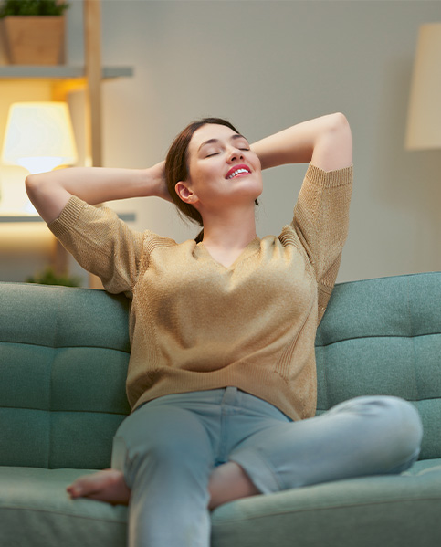 A young woman with brown hair is relaxing on a sofa. (photo)